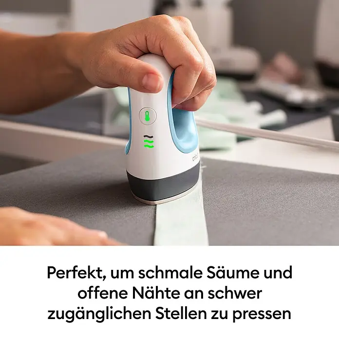 Cricut Transferpresse EasyPress Mini - Passend für: Bügelfolien, Drucktechnologie: Wärmeübertragung - Eine Hand verwendet ein weiß-blaues Mini-Bügeleisen mit grünen Lichtern, um einen hellgrünen Stoffstreifen zu bügeln.