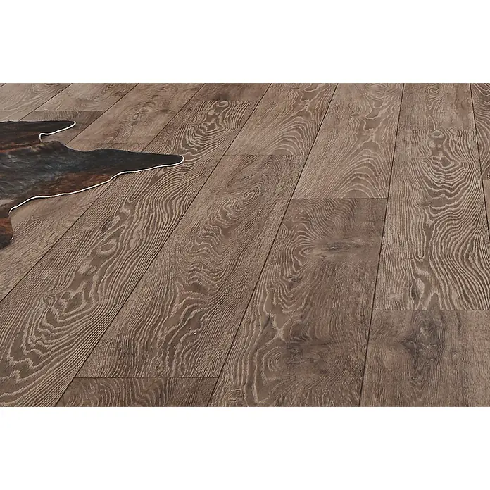LOGOCLIC Aquaprotect Laminat - Night Oak, Landhausdiele, 1.288 x 195 x 8 mm - Brauner Holzboden mit ausgeprägter Maserung, teilweise von einem Kuhfellteppich bedeckt.
