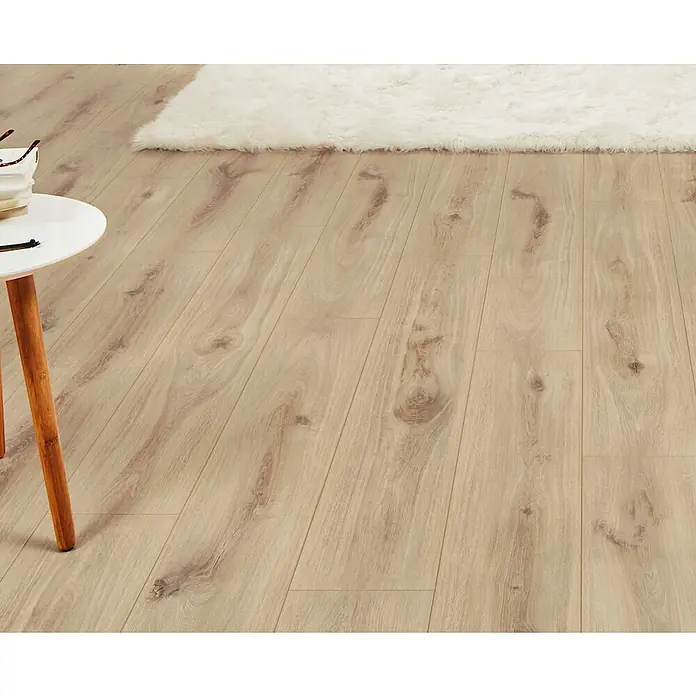 LOGOCLIC Aquaprotect Laminat - Sunset Oak, Landhausdiele, 1.288 x 195 x 8 mm - Heller Laminatboden in Holzoptik mit einem flauschigen weißen Teppich und einem Beistelltisch, der seine natürliche Maserung in einem Raum zeigt.