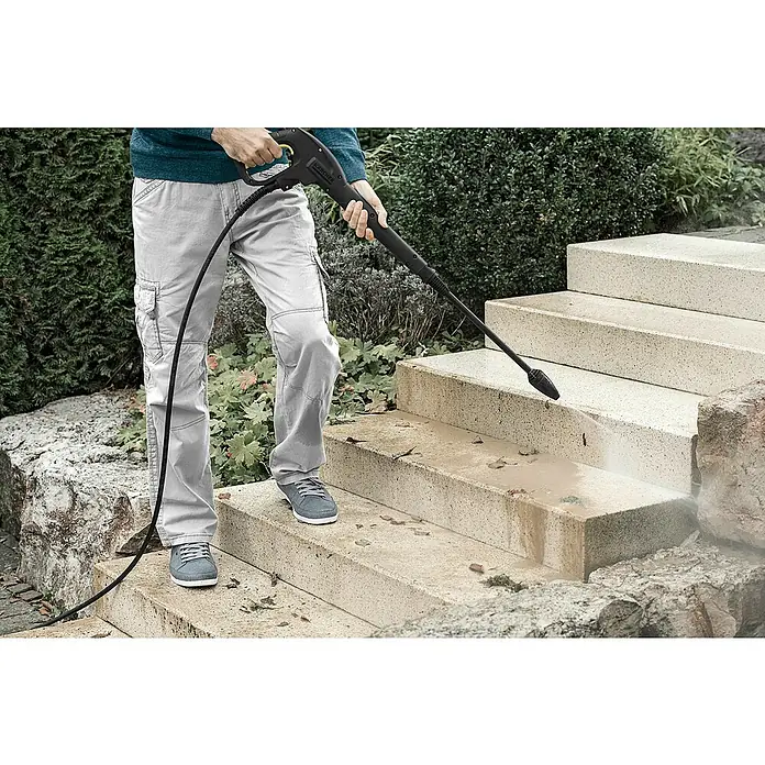 Kärcher Dreckfräse DB 180 - Passend für: Kärcher Hochdruckreiniger K7 - Person reinigt Außentreppe mit schwarzem Kärcher Hochdruckreiniger mit gelbem Abzug.