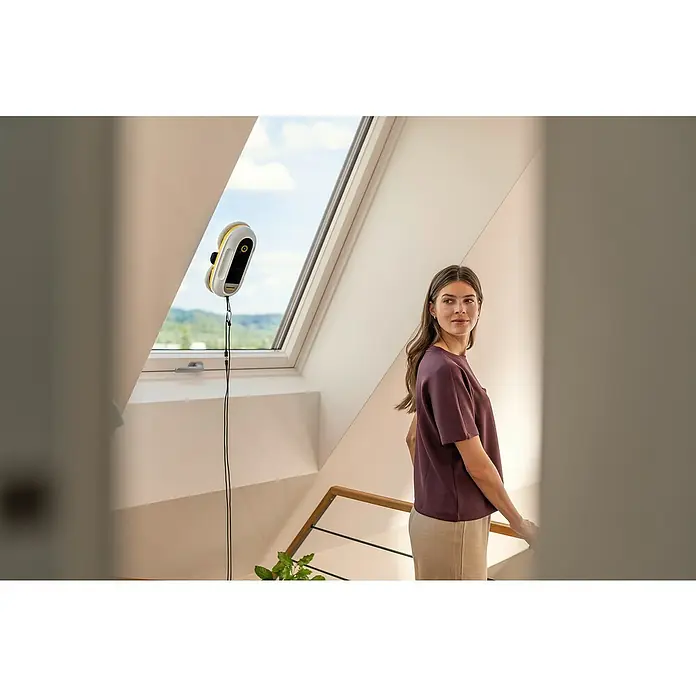 Kärcher Fensterreinigungsroboter RCW 2 - Wassertankvolumen Roboter: 70 ml, Saugkraft: 3.300 Pa - Weiß-gelber Kärcher Fensterreinigungsroboter reinigt ein schräges Dachfenster.
