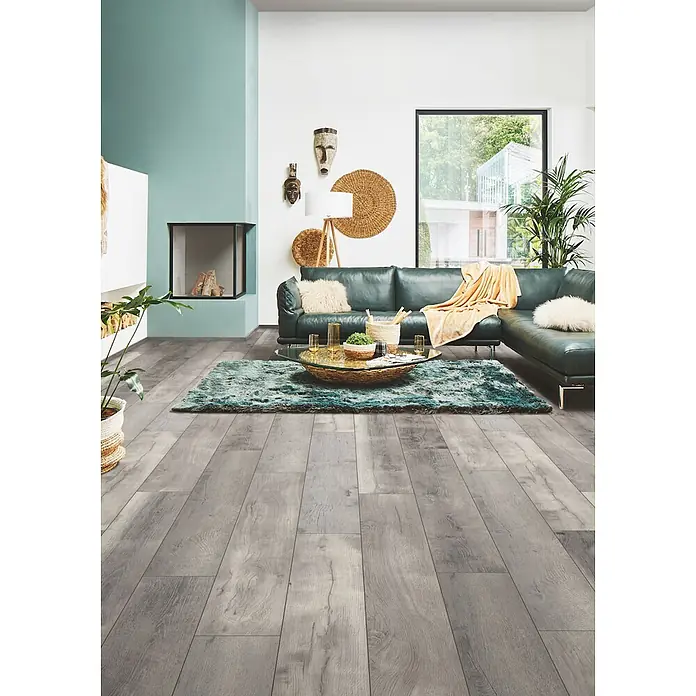 LOGOCLIC Aquaprotect Laminat - Tasso Oak, Landhausdiele, 1.288 x 245 x 8 mm - Hellgraues Holzoptik-Laminat in modernem Wohnzimmer, vom Vordergrund bis unter Sofa und Teppich verlegt.
