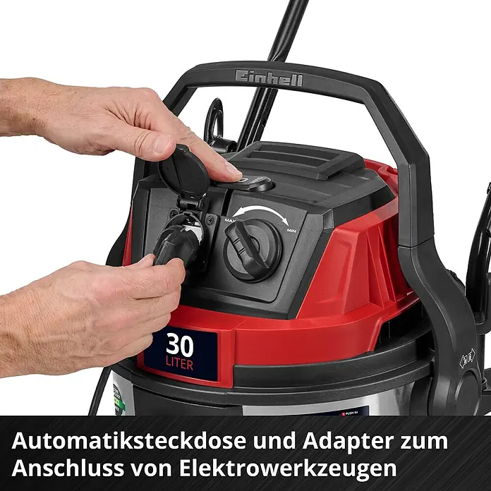 Einhell Elektro-Nass- & Trockensauger TE-VC 3080 SACL - 1.150 W, Behältervolumen: 30 l, Halbautomatisch - Eine Person steckt einen Adapter in die Automatiksteckdose eines rot-schwarzen Einhell 30-Liter Nass-/Trockensaugers mit MAX/MIN-Regler.