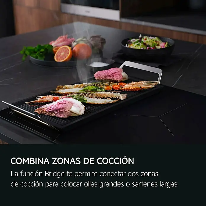 AEG Placa de cocción TO84IU0FFB - Número de fogones de inducción: 4 ud. - Placa de inducción AEG con plancha cocinando marisco y verduras, mostrando la función Bridge para recipientes grandes.