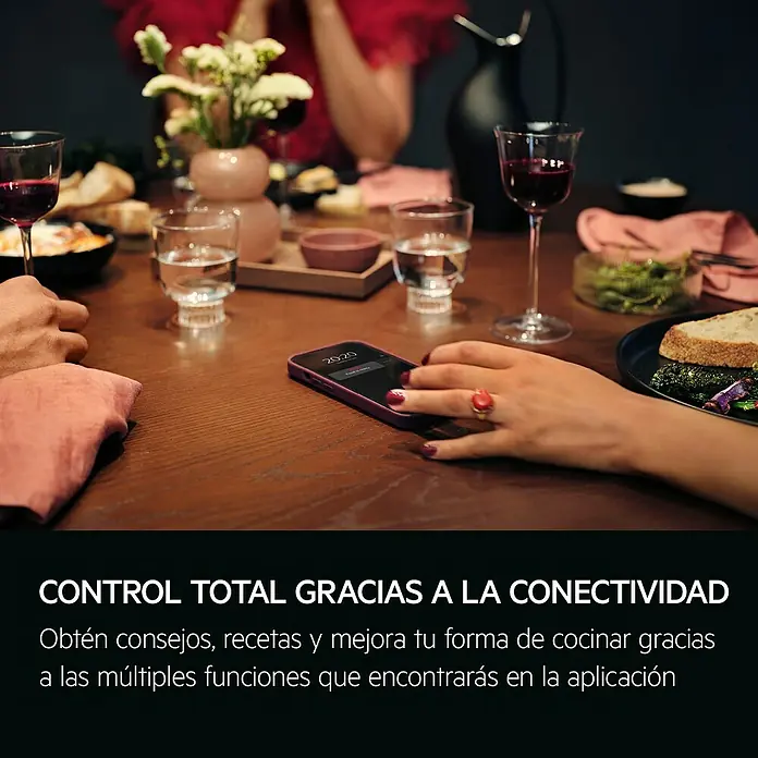 AEG Horno empotrado TR6PB531SB - Número de tipos de calentamiento: 9 ud., 72 l - Un smartphone mostrando 'Food is ready' en una mesa de cena, ilustrando el control de electrodomésticos inteligentes. Una mano se acerca al teléfono.