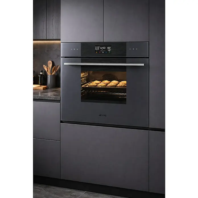 Smeg Horno empotrado SOP6102S2PG - Número de tipos de calentamiento: 12 ud., Volumen horno: 68 l - Horno empotrado gris oscuro con pantalla digital, horneando pasteles en una cocina moderna.
