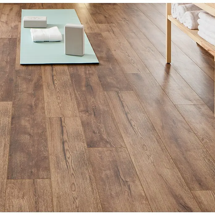 LOGOCLIC Ambienta Laminat - Eiche Mirandola, Landhausdiele, 1.288 x 195 x 10 mm - Hellblaue Yogamatte, zwei graue Yogablöcke und ein weißes Handtuch auf Holzboden, bereit für Übungen.