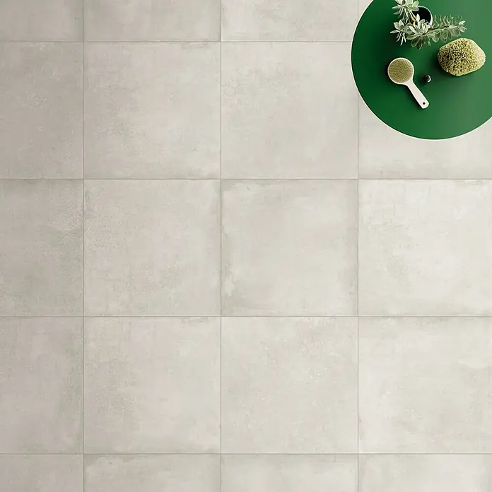 DryTile Feinsteinzeugfliese Studio Lime - 60 x 60 cm, Beige, Matt - Große, hellgraue Fliesen in Betonoptik als Bodenbelag mit Wellness-Artikeln.