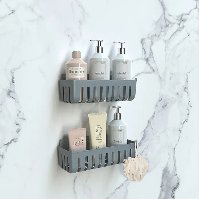 Cesta de baño Molly - 11 x 25 x 9 cm, Plástico, Gris - Dos estantes de ducha de plástico gris montados en una pared de mármol, con varias botellas y una esponja.