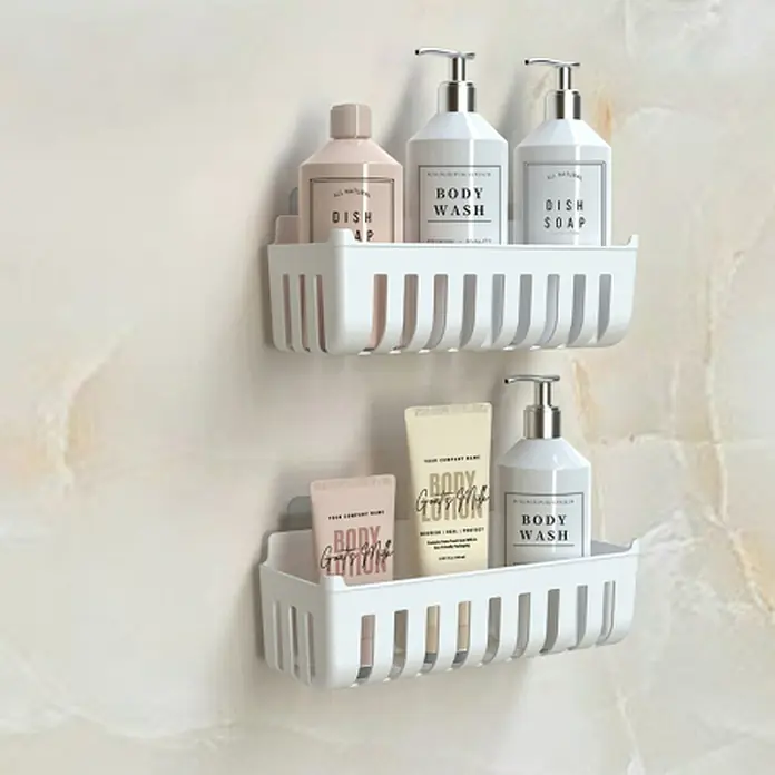 Cesta de baño Molly - 11 x 25 x 9 cm, Plástico, Blanco - Dos estantes de ducha de plástico blancos montados en la pared con varias botellas.