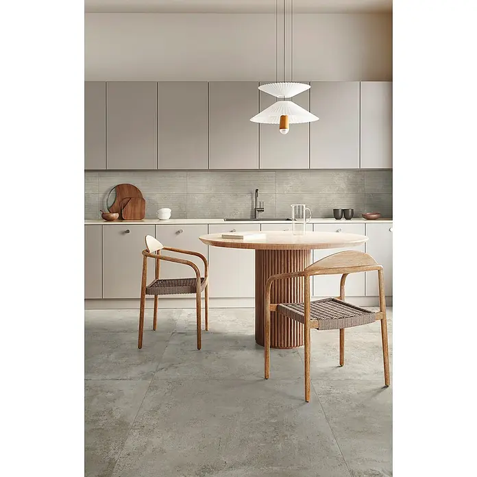 Feinsteinzeugfliese Urban - 60 x 60 cm, Taupe, Matt - Moderne Küche mit hellgrauen Schränken, texturierter Rückwand, rundem Holztisch und zwei hellen Holzstühlen mit geflochtenen Sitzen.
