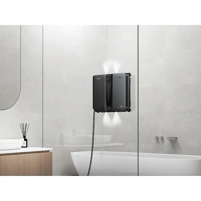 Mova Fensterreinigungsroboter N1 - Wassertankvolumen Roboter: 120 ml, Saugkraft: 8.000 Pa - Dunkelgrauer MOVA N1 Fensterputzroboter an Duschwand aus Glas mit Lichtstrahlen.