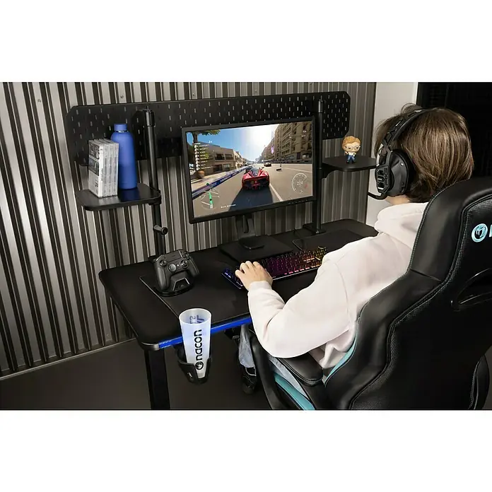 Nacon Mesa de escritorio PCGD-ELEC - L x An x Al: 60 x 120 x 118 cm, Iluminación LED, Altura regulable - Persona jugando en escritorio negro con textura de carbono, brazo de monitor, estantes, soporte de mando y posavasos.