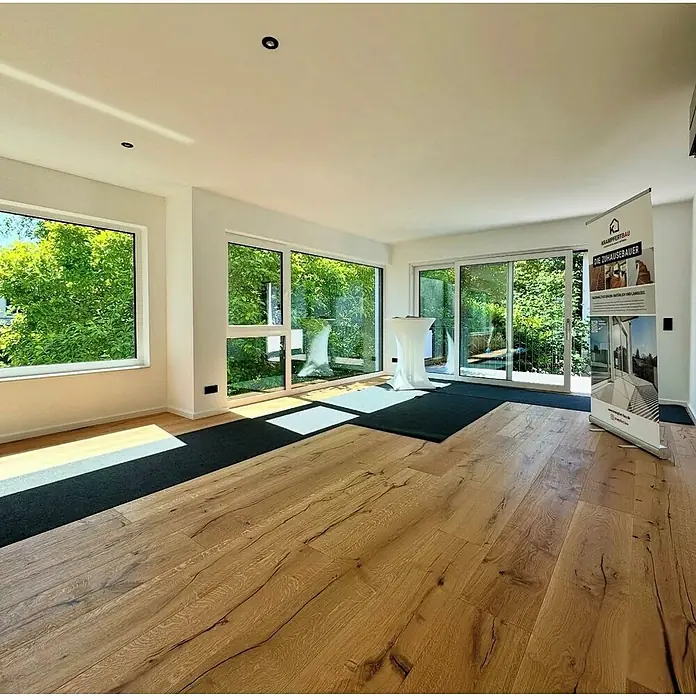 Parkett Schlossdiele Eiche Florida - L x B x H: 2.200 x 260 x 15 mm - Heller Eichenholzparkettboden mit natürlicher Maserung in einem hellen, modernen Raum mit großen Fenstern.
