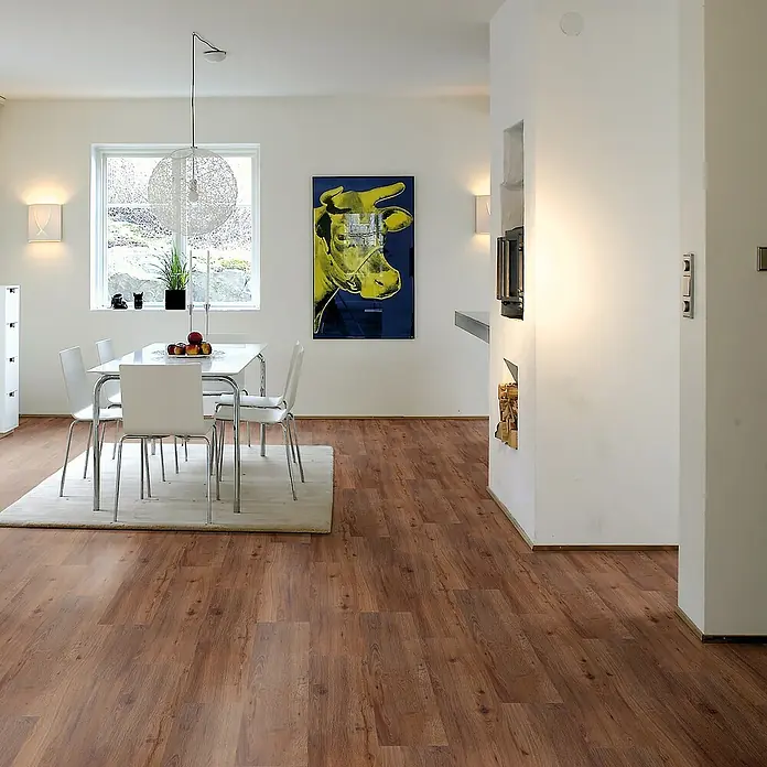 b!design Vinylboden SPC - Eiche Avignon, Landhausdiele, 1.220 x 182 x 4,3 mm - Warmbrauner Holzboden in einem hellen, modernen Essbereich verlegt. Die Dielen weisen unterschiedliche Maserungen auf.