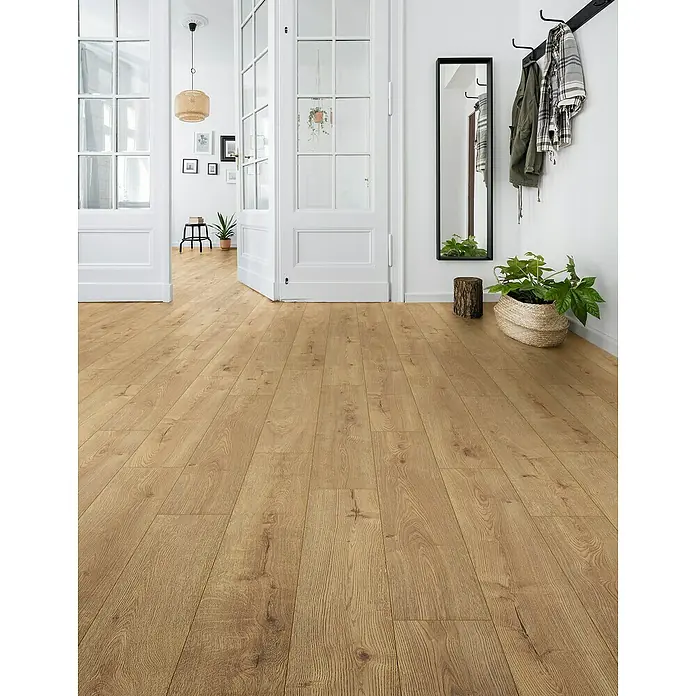 Laminado Hidro Sundance - 1.288 x 195 x 10 mm, Marrón, AC5, Resistente a la presión - Suelo de aspecto madera clara colocado en diagonal en un pasillo luminoso, extendiéndose a través de puertas abiertas.