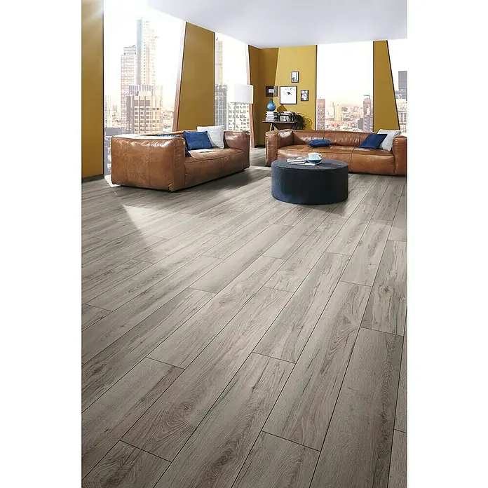 Laminado Longbow - 1.288 x 195 x 8 mm, Gris, AC4 - Suelo de tablones de madera clara con veta natural en un salón moderno.