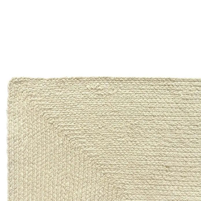 Alfombra exterior In/Out Ebro - Crema, 110 x 60 cm, 100% Polietileno - Esquina de alfombra trenzada beige mostrando el tejido de fibra natural texturizada.