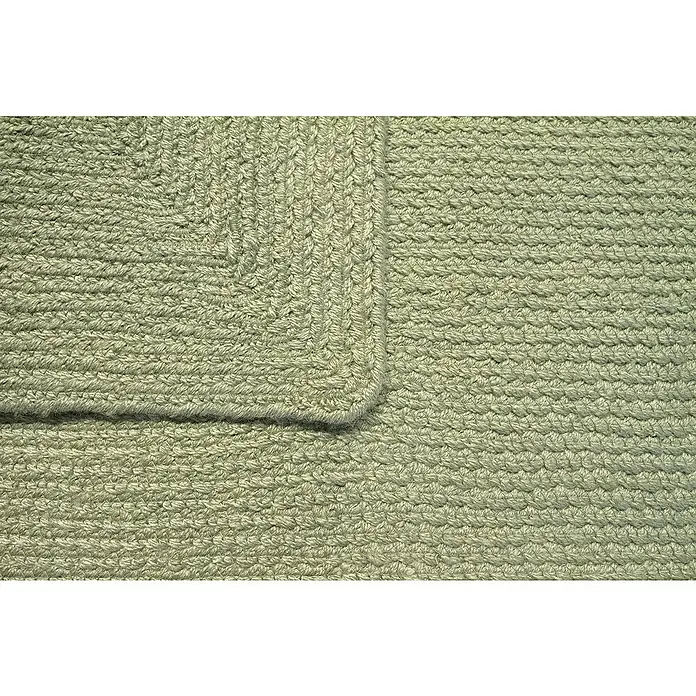Alfombra exterior In/Out Ebro - Verde, 110 x 60 cm, 100% Polietileno - Primer plano de una alfombra trenzada verde claro con su intrincada textura tejida.