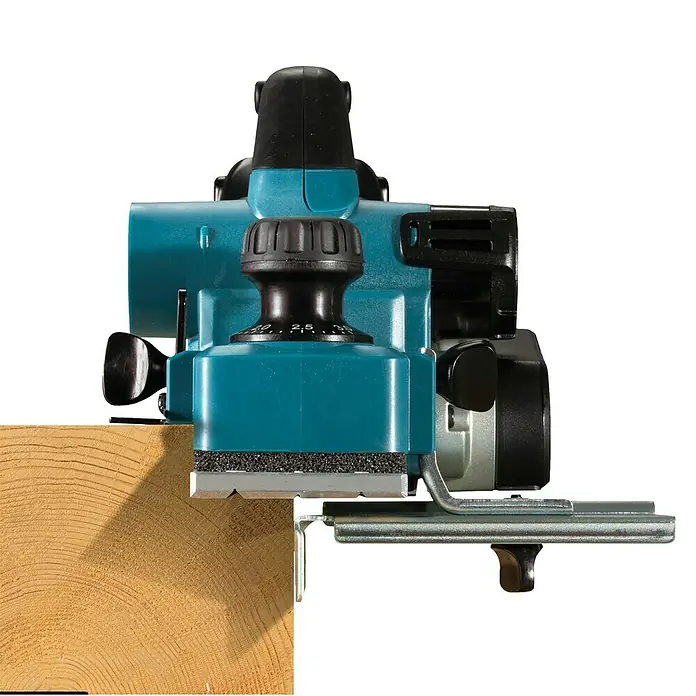 Makita LXT 18V Akku-Hobel - 18 V, Ohne Akku, Leerlaufdrehzahl: 12.000 U/min - Türkiser und schwarzer Elektrohobel mit silberner Klinge, hobelt einen hellbraunen Holzbalken. Zeigt Tiefeneinstellknopf und Seitenführung.