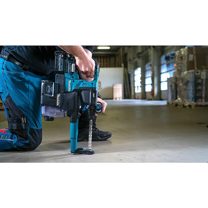 Makita XGT 40V max. Akku-Kombihammer HR003GM201 - 40 V, 2 Akkus, 4 Ah, 2,8 J - Makita Akku-Bohrhammer mit Staubabsaugung, türkis und schwarz, von Person kniend auf Betonboden gehalten.