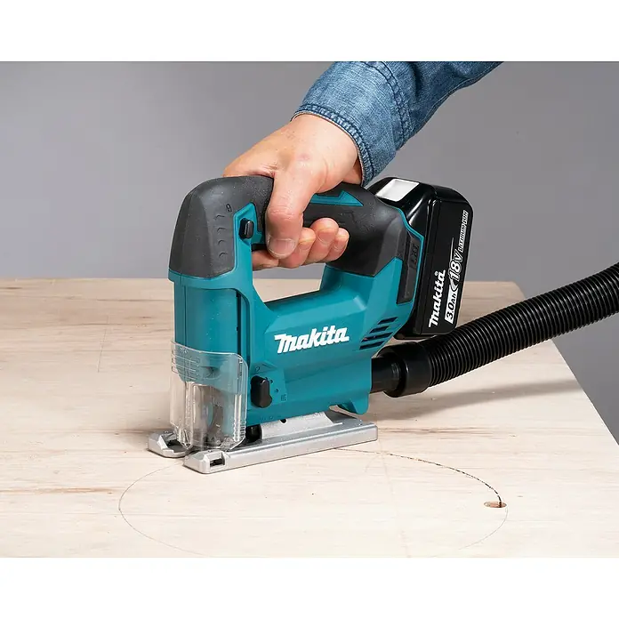 Makita LXT 18V Akku-Pendelhubstichsäge DJV186Z - 18 V, Ohne Akku, 2.900 /min - Türkis-schwarze Makita Akku-Stichsäge schneidet Kreise in Holz, betrieben mit 18V Akku, mit angeschlossenem Staubschlauch.