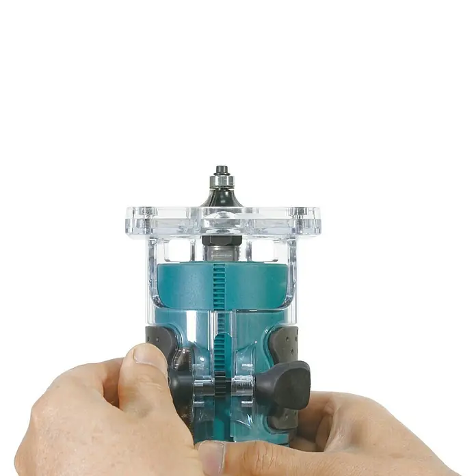 Makita LXT 18V Akku-Kantenfräser DRT52Z - 18 V, Ohne Akku, Leerlaufdrehzahl: 30.000 U/min - Hände halten einen türkisfarbenen und transparenten Kompaktfräser mit schwarzem Bit, bereit zur Benutzung.