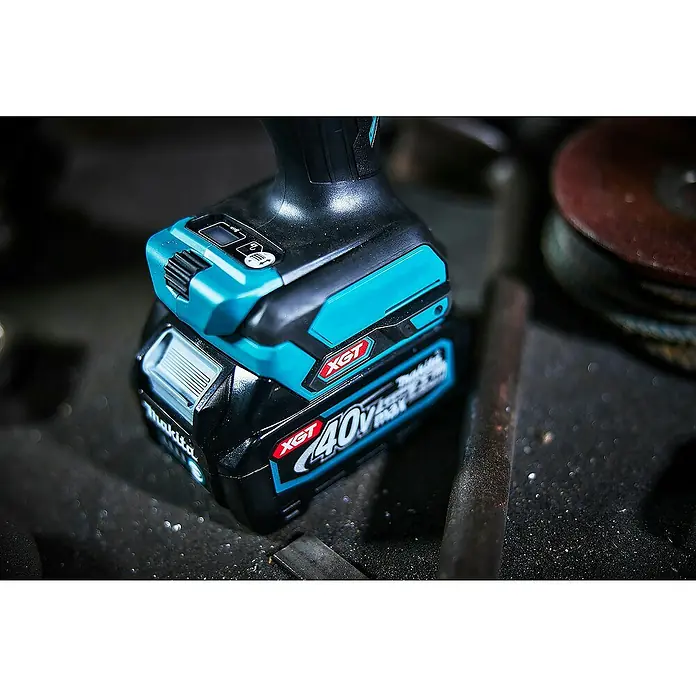 Makita XGT 40V max. Akku-Schlagbohrschrauber HP001GD201 - 40 V, 2 Akkus, 2,5 Ah, 41 Nm - Nahaufnahme eines schwarz-türkisen Makita XGT 40V Max Akkus an einem Werkzeuggriff, auf dunklem Untergrund.