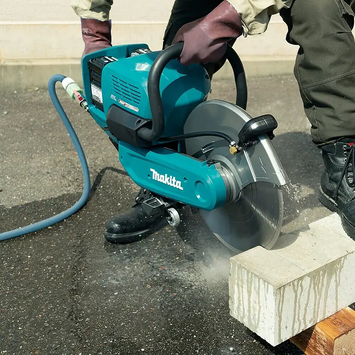 Makita XGT 40V max. Akku-Trennschleifer - Ohne Akku, 5.300 U/min - Teal Makita Trennsäge schneidet einen Betonblock unter Wasserkühlung.