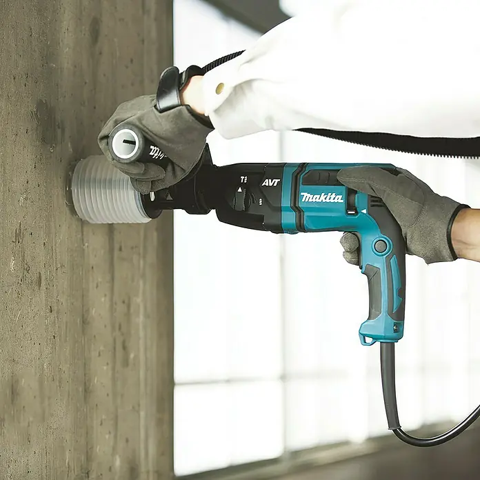 Makita Bohrhammer HR1841FJ - 470 W, 1,4 J, SDS-Plus-Aufnahme - Türkis-schwarzer Makita Bohrhammer mit Staubabsaugung bohrt in Betonwand, von behandschuhten Händen gehalten.