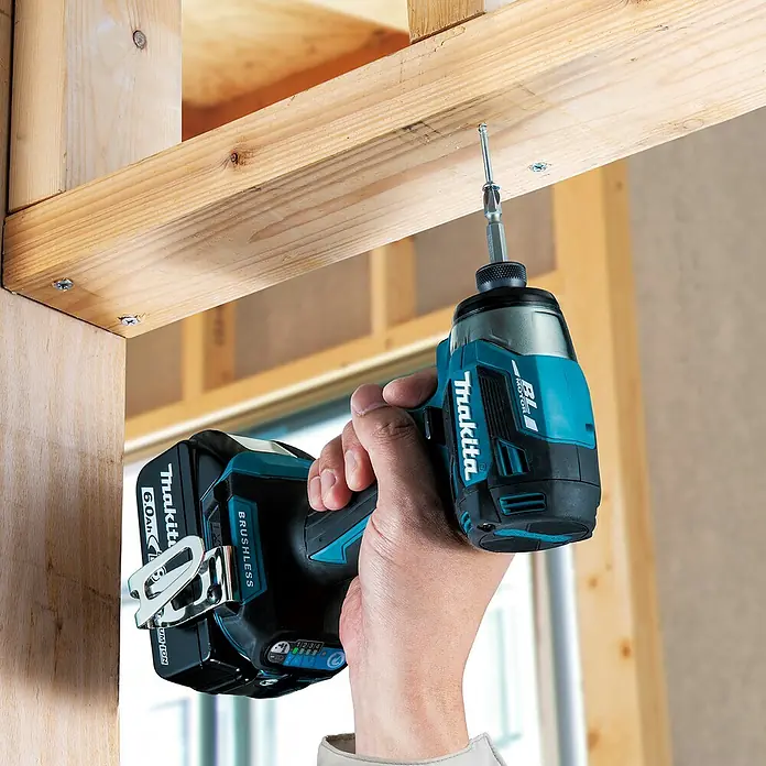 Makita LXT 18V Akku-Schlagschrauber DTD173Z - 18 V, Ohne Akku - Türkis-schwarzer Makita Schlagschrauber mit 6.0Ah Akku, der eine Schraube in einen Holzbalken treibt.