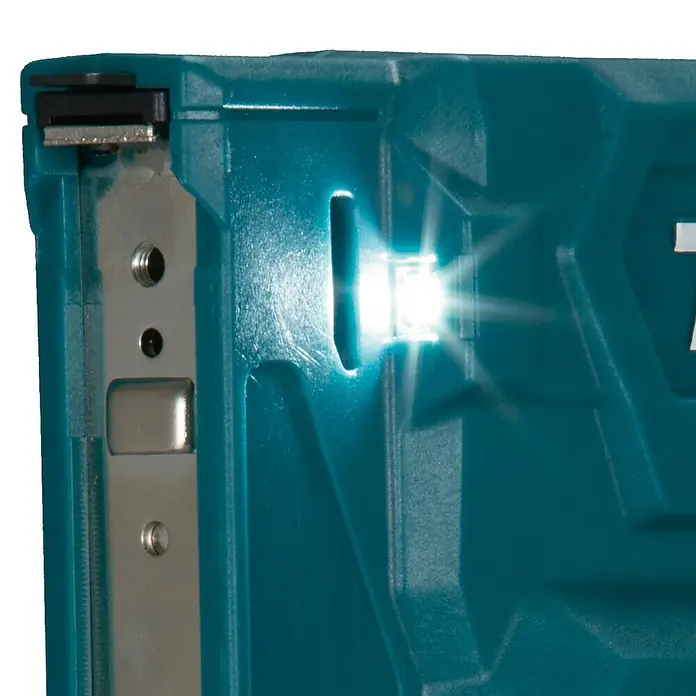 Makita CXT 12V max. Akku-Tacker ST113DSMJ - 12 V, 2 Akkus, 4 Ah - Nahaufnahme eines türkisfarbenen Werkzeugs mit heller LED-Beleuchtung eines Schlitzes und metallischen Innenteilen.