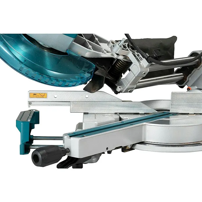 Makita Kapp- & Gehrungssäge LS1110F - 1.400 W, Durchmesser Sägeblatt: 260 mm, Leerlaufdrehzahl: 4.500 U/min - Silber-graue und türkisfarbene Gehrungssäge mit transparentem blauem Blattschutz und schwarzem Staubsack, zeigt den Schneidemechanismus.