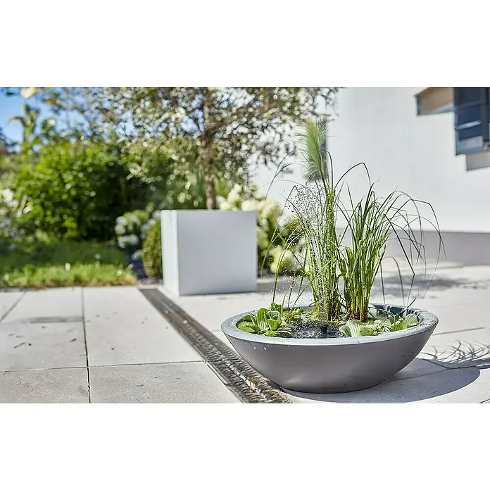 Heissner Zierbrunnen Solar Wassergarten Lotusgarden - Anthrazit, L x B x H: 58 x 58 x 19 cm - Grauer Schalenbrunnen mit Wasserpflanzen und sprudelndem Wasser in einer Gartenumgebung.