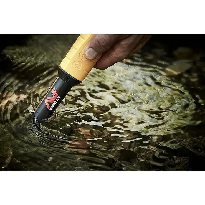 Minelab Metalldetektor PRO-FIND 35 Pinpoint - L x B x H: 50 x 50 x 250 mm - Hand taucht einen gelb-schwarzen Minelab Pinpointer in klares, fließendes Wasser.