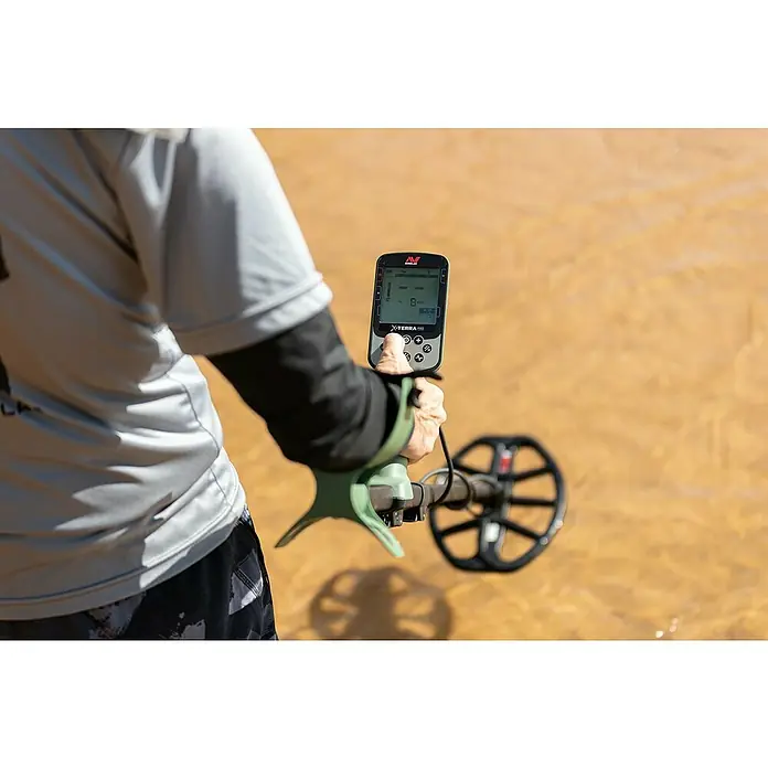 Minelab Metalldetektor X-TERRA PRO - 3,7 V, 1 Akku, 5.100 mAh, L x B x H: 230 x 310 x 1.380 mm - Eine Person nutzt einen Minelab X-Terra Pro Metalldetektor, dessen Suchspule in flaches Wasser getaucht ist.