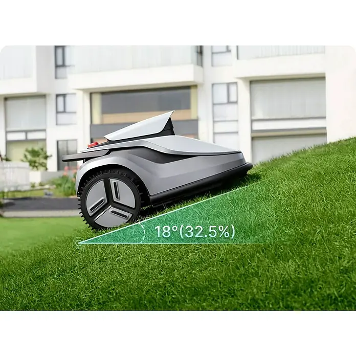 Terramow Mähroboter-Set V1000 inkl. Garage - 1.200 m², Schnittbreite: 20,3 cm, Kamera-gestützte Navigation - Eleganter silber-grauer Mähroboter erklimmt einen Grashang und zeigt seine 18° (32,5%) Steigfähigkeit.