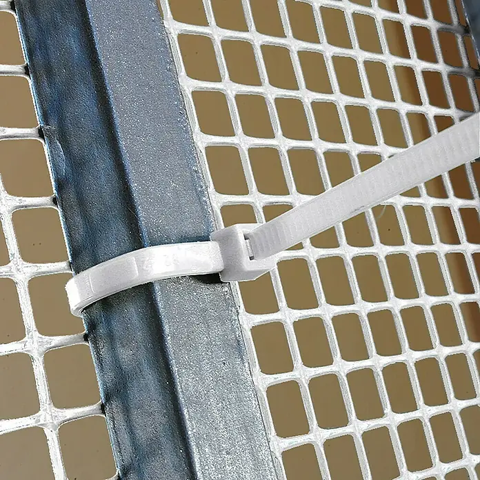 Tenax Set de bridas para cables - Largo: 29 cm, 50 ud., Blanco - Brida de cable blanca asegurando un panel de malla blanco a un marco de metal gris.
