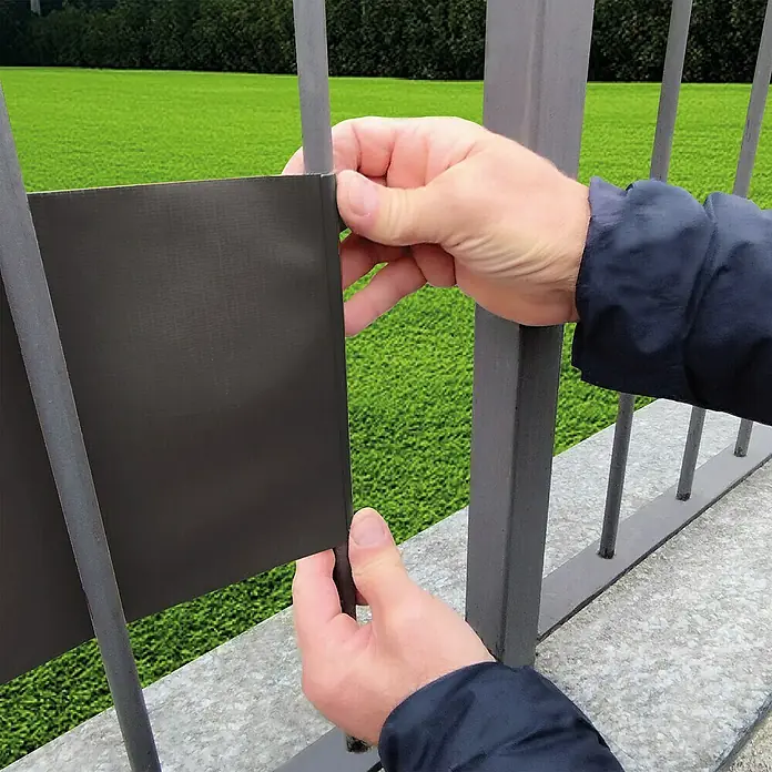 Tenax Malla de ocultación Twist - 35 x 0,19 m, Antracita - Pantalla de privacidad gris oscuro instalándose en una valla metálica.