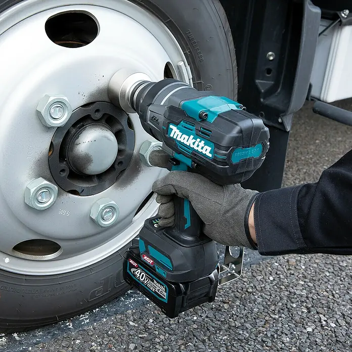 Makita XGT 40V max. Akku-Schlagschrauber TW001GZ - 40 V, Ohne Akku - Eine Person benutzt einen türkis-schwarzen Makita 40V Schlagschrauber an den Radmuttern eines LKW-Rades.