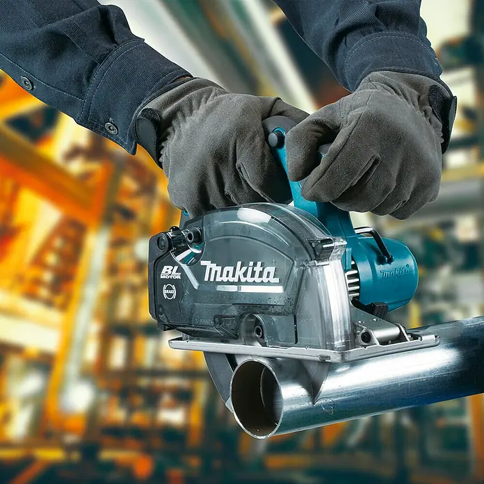 Makita LXT 18V Akku-Handkreissäge DCS553RTJ - 18 V, 2 Akkus, 5 Ah - Eine Person mit Handschuhen verwendet eine türkis-schwarze Makita Kreissäge mit transparentem Blattschutz, um ein silbernes Metallrohr zu schneiden.