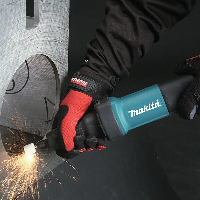 Makita Geradschleifer GD0600 - 400 W, 25.000 U/min - Eine behandschuhte Hand hält einen blau-schwarzen Makita Geradschleifer, der Metall bearbeitet und Funken sprüht.