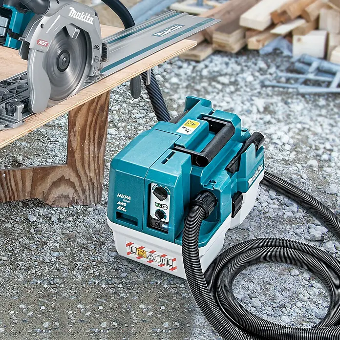 Makita XGT 40V max. Akku-Nass-Trockensauger VC013GLZ03 - 40 V, Ohne Akku, Behältervolumen: 7,5 l - Makita Kreissäge auf Führungsschiene, verbunden mit einem türkis-weißen Staubsauger, bereit zum Holzzuschnitt.