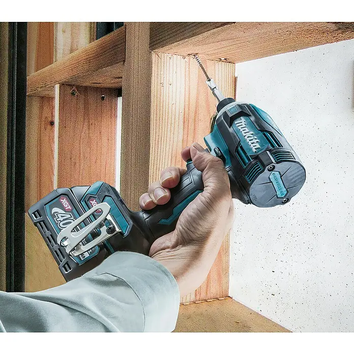 Makita XGT 40V max. Akku-Schlagschrauber TD001GD201 - 40 V, 2 Akkus, 2,5 Ah - Ein teal-schwarzer Makita Schlagschrauber mit 40V XGT Akku treibt eine Schraube in einen Holzrahmen.