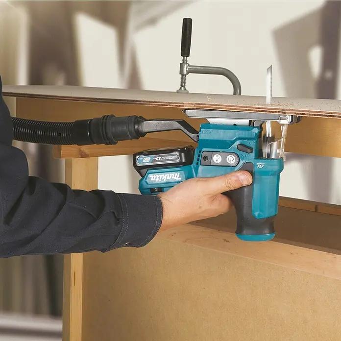 Makita CXT 12V max. Akku-Stichsäge JV102DZ - 12 V, Ohne Akku - Eine Person nutzt eine türkis-schwarze Makita 12Vmax Akku-Stichsäge mit Staubabsaugung zum Holzsägen.