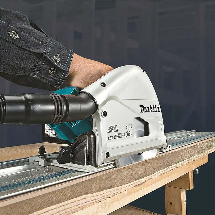 Makita LXT 18V Akku-Tauchsäge DSP600ZJ - 18 V, Ohne Akku, 2.500 U/min - 6.300 U/min - Hellgraue Makita Tauchsäge mit schwarzem Absaugschlauch, schneidet Holz auf einer Führungsschiene.