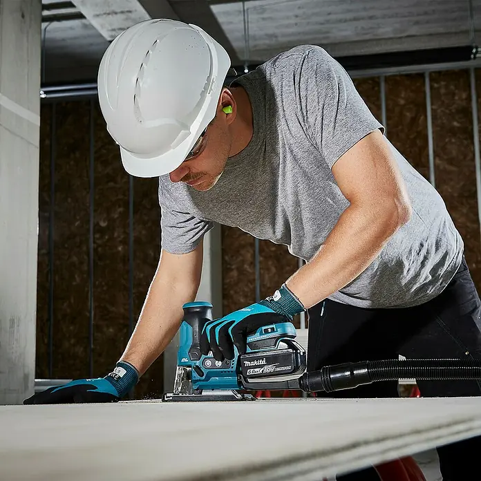 Makita LXT 18V Akku-Pendelhubstichsäge DJV185Z - 18 V, Ohne Akku, Leerlaufhubzahl: 800 /min - 3.000 /min - Eine Person verwendet eine türkis-schwarze Makita Akku-Stichsäge mit Staubabsaugung auf einer hellen Oberfläche.