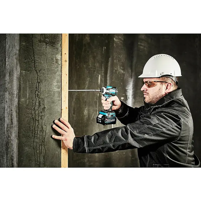 Makita XGT 40V max. Llave de impacto de batería TD001GZ - 40 V, Sin batería - Hombre usando un taladro de impacto Makita azul y negro para atornillar en un listón de madera.