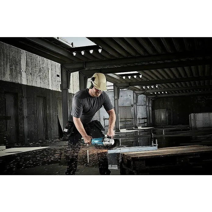Makita Elektro-Winkelschleifer GA9020RFK3 - 2.200 W, Durchmesser Scheibe: 230 mm, Leerlaufdrehzahl: 6.600 U/min - Ein Arbeiter schneidet Metall mit einem hellblauen Makita Winkelschleifer, Funken sprühen.