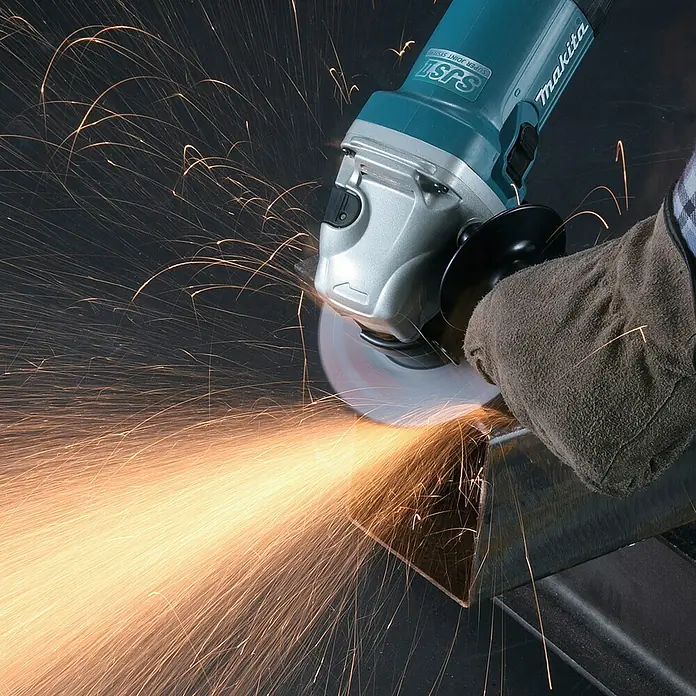 Makita Elektro-Winkelschleifer GA5040RZ1 - 1.100 W, Leerlaufdrehzahl: 11.000 U/min - Winkelschleifer mit türkisfarbenem Gehäuse und silbernem Kopf schleift Metall, erzeugt helle Funken.
